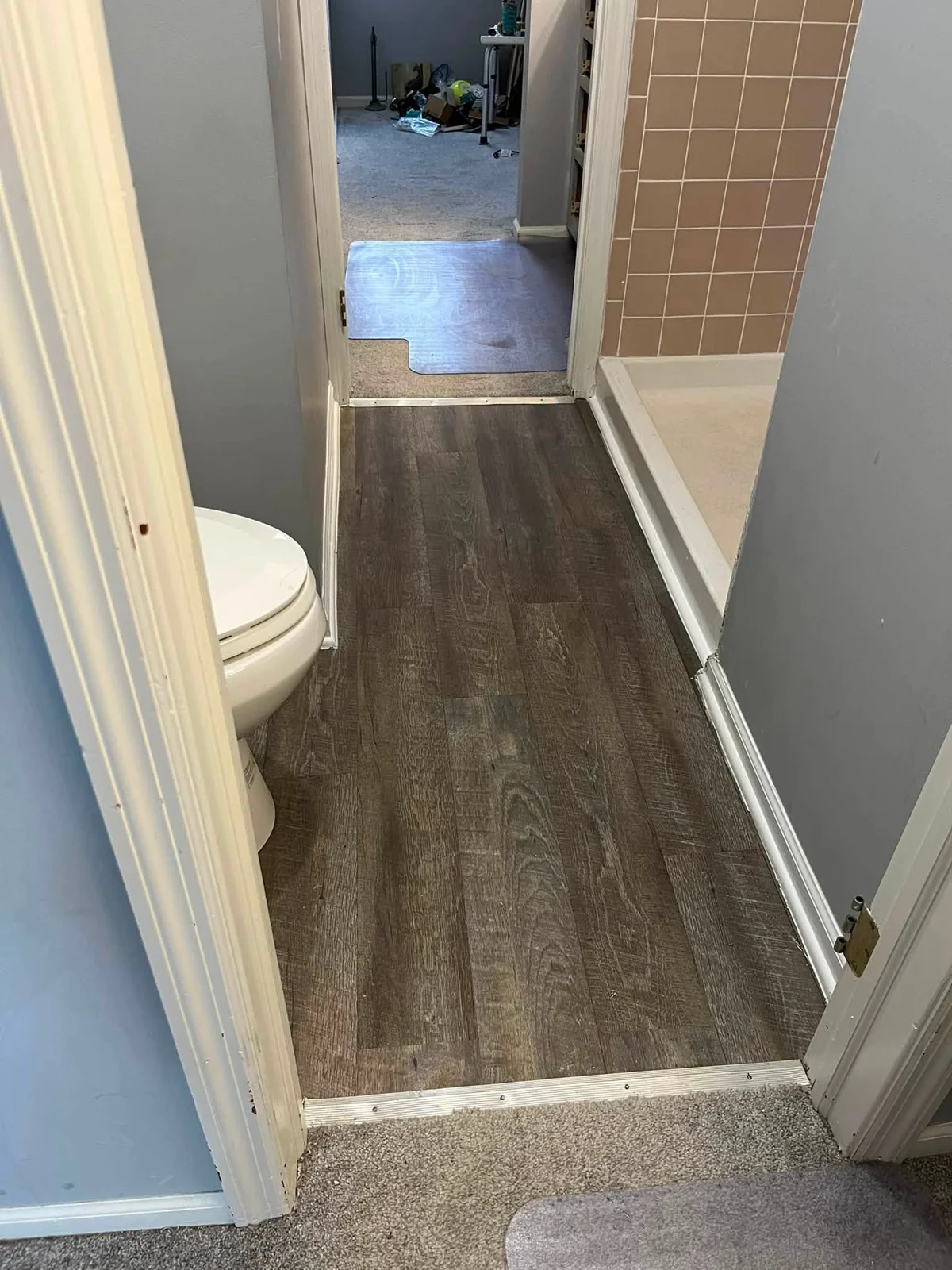 Updated bathroom floor beside a tiled shower